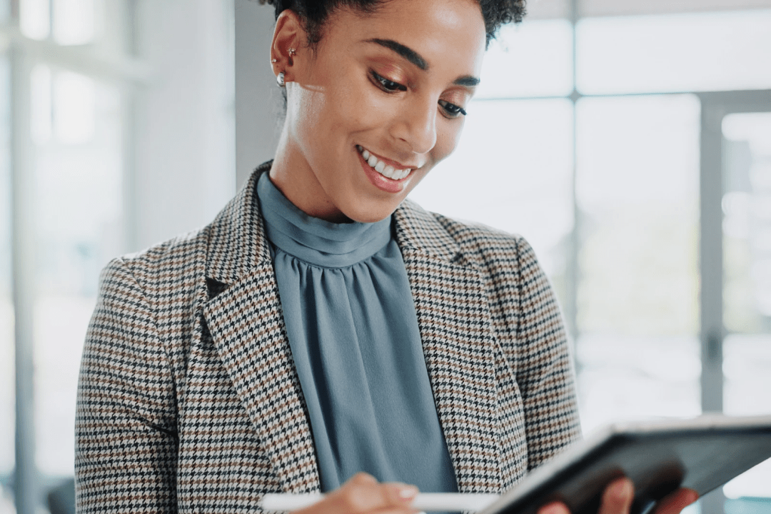 Screenshot showing woman smiling while interacting with a tablet
